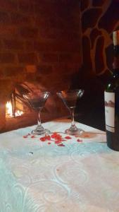 una mesa con dos copas y una botella de vino en La cabaña de sol, en Aquitania