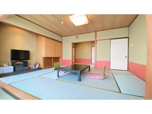 sala de estar con mesa y TV en Nishiura Grand Hotel Kikkei - Vacation STAY 85448v en Gamagori