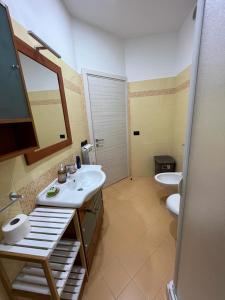ein Badezimmer mit zwei Waschbecken, einem Spiegel und einem WC in der Unterkunft Casa Vacanze Caltagirone in Caltagirone