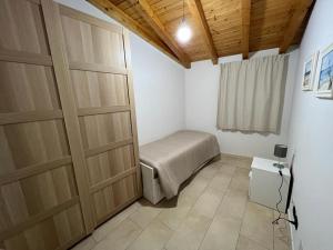 Schlafzimmer mit zwei Holztüren und einem Bett in der Unterkunft Casa Vacanze Caltagirone in Caltagirone