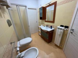 ein Badezimmer mit einem Waschbecken, einem WC und einem Spiegel in der Unterkunft Casa Vacanze Caltagirone in Caltagirone