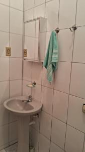 La salle de bains est pourvue d'un lavabo et d'une serviette verte. dans l'établissement Casa Caraguatatuba Nelson, à Caraguatatuba
