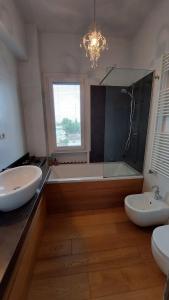 ein Badezimmer mit zwei Waschbecken, einer Badewanne und einem Fenster in der Unterkunft Borgo San Giuliano in Rimini
