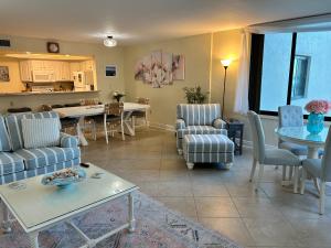 a living room with chairs and a table and a kitchen at Always Summer On a White Sandy Beach in Fort Myers Beach