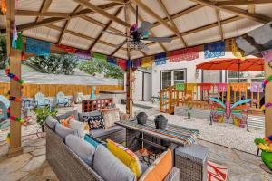 un patio al aire libre con sofás, mesa y sombrilla en The Coco House/Lone Star Dist/Jacuzzi/Golf Cart, en San Antonio