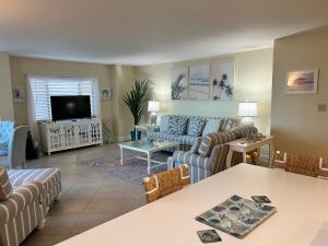 a living room with a couch and a tv at Always Summer On a White Sandy Beach in Fort Myers Beach