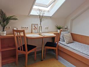 a dining room table with two chairs and a skylight at Híd Ifjúsági Szálló in Dunaújváros