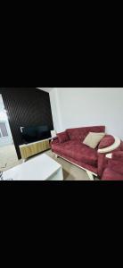 a living room with a red couch and a table at Furnished Two bedroom apartment in Irbid in petra st in Irbid