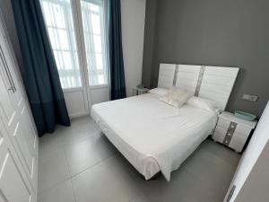 een kleine slaapkamer met een wit bed en een raam bij Piso deluxe en pleno centro - San Juan 39 in Sanlúcar de Barrameda