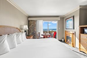 フォートブラッグにあるSurf and Sand Lodgeの大きなベッドと窓が備わるホテルルームです。
