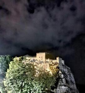 a castle on top of a mountain at night at A Casa da Paola in Caccamo