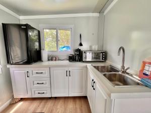 a kitchen with white cabinets and a sink and a window at Tony's Travels in Camaceyes