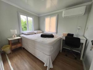 1 dormitorio con cama, escritorio y silla en Tony's Travels, en Camaceyes