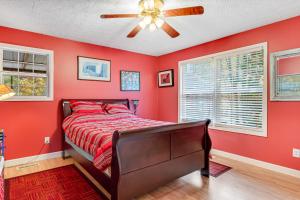 - une chambre rouge avec un lit et un ventilateur de plafond dans l'établissement Relax at Saddleback, à Mill Spring