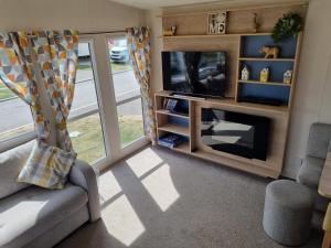 a living room with a fireplace and a television at 58 Lancaster crescent in Tattershall +1 photo