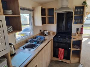 a small kitchen with a stove and a sink at 58 Lancaster crescent in Tattershall
