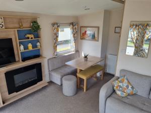 a living room with a couch and a table and a tv at 58 Lancaster crescent in Tattershall