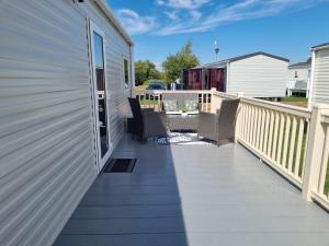 a deck with chairs on the side of a house at 58 Lancaster crescent in Tattershall