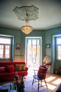 sala de estar con sofá rojo y lámpara de araña en Coruche - A casa do Baloiço, en Coruche