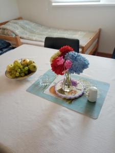 a table with a vase of flowers and a plate of fruit at Azra in Visoko +25 photos
