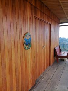 una pared de madera con una puerta y una señal en ella en Brisa de la montaña:Cabaña con vista al bosque de Platanillo y al mar, en Platanillo