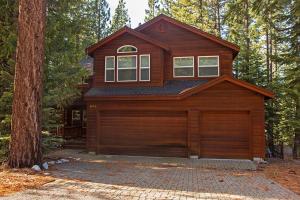 a house with a garage in the woods at Big Luxury South Lake Tahoe Home in South Lake Tahoe