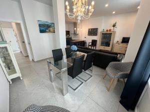 een woonkamer met een glazen tafel en stoelen bij Piso deluxe en pleno centro - San Juan 39 in Sanlúcar de Barrameda