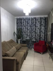 a living room with a couch and a red chair at CASA em CALDAS NOVAS in Caldas Novas