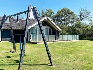 a pair of swings in front of a house at 6 person holiday home in Vinderup in Vinderup