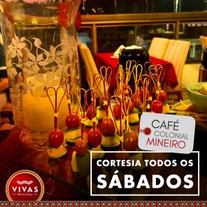 una mesa con un montón de pequeñas cerezas en palitos en Vivas Hotel e Casa en Monte Sião