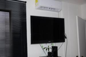 TV de pantalla plana colgada en una pared blanca en Aparta estudio acogedor, ubicación Chipichape, en Cali