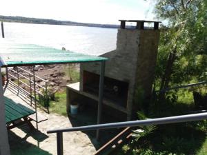 a stone fireplace next to a body of water at Buena Vista in Salto