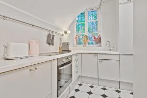 a white kitchen with a sink and a window at Splendid appartment in the heart of Paris - Welkeys in Paris