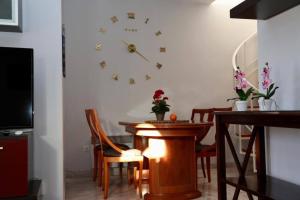 a dining room with a clock on the wall at Dúplex Bornoi in Vinarós +27 photos