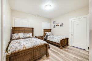 2 camas en un dormitorio con paredes blancas y suelo de madera en Sunny Turlock Cottage Walk to Downtown!, en Turlock