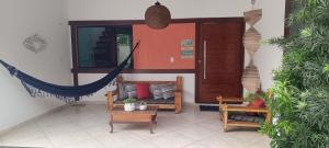 a living room with a hammock and a room with plants at Casa Duas Torres in Búzios