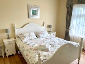 a bedroom with a white bed with flowers on it at Baywater in Kingscote