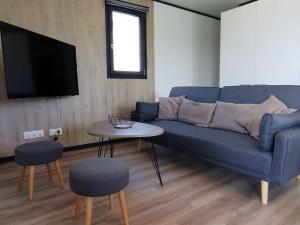 sala de estar con sofá azul y mesa en Cottage Nature Piscine partagée Vue Vilaine, en Arzal