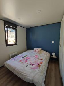1 dormitorio con 1 cama con pared azul en Cottage Nature Piscine partagée Vue Vilaine, en Arzal