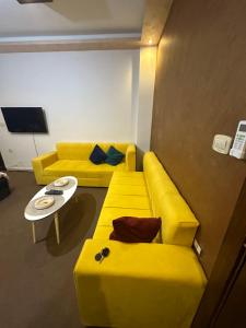 sala de estar con sofá amarillo y mesa en Furnished Studio for rent, en Irbid