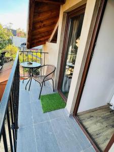Un balcón de una casa con una mesa y sillas. en The Union Square Apartament, en Oradea