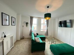 een woonkamer met een groene bank en een tafel bij Serene Ocean Side Apartment BTN in Brighton & Hove