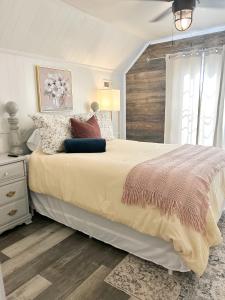 una camera bianca con un grande letto con cuscini di Best Life Now Cottage a Crane Hill