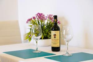 Una botella de vino y dos copas en una mesa en La casetta in pietra - nel CUORE di OSTUNI, en Ostuni