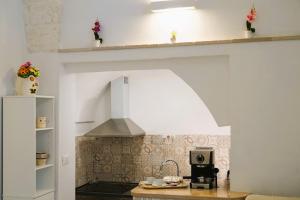 una cocina con capucha sobre una barra de cocina en La casetta in pietra - nel CUORE di OSTUNI, en Ostuni
