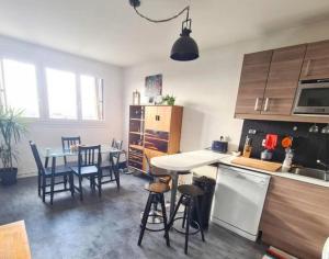 a kitchen with a table and chairs and a dining room at Appartement à 20mn de Paris et 40mn de Disney in Fontenay-sous-Bois