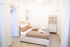 Un dormitorio con una cama con toallas. en La casetta in pietra - nel CUORE di OSTUNI, en Ostuni