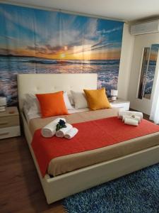 a bedroom with a large bed with a painting on the wall at La Petite Maison in Aci Castello