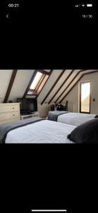 um quarto no sótão com 2 camas e uma janela em Lovely family house next to the exhibition em Dusseldorf