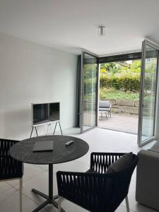 a living room with a table and chairs and a television at Traumhafte Wohnung am Bodensee in Staad